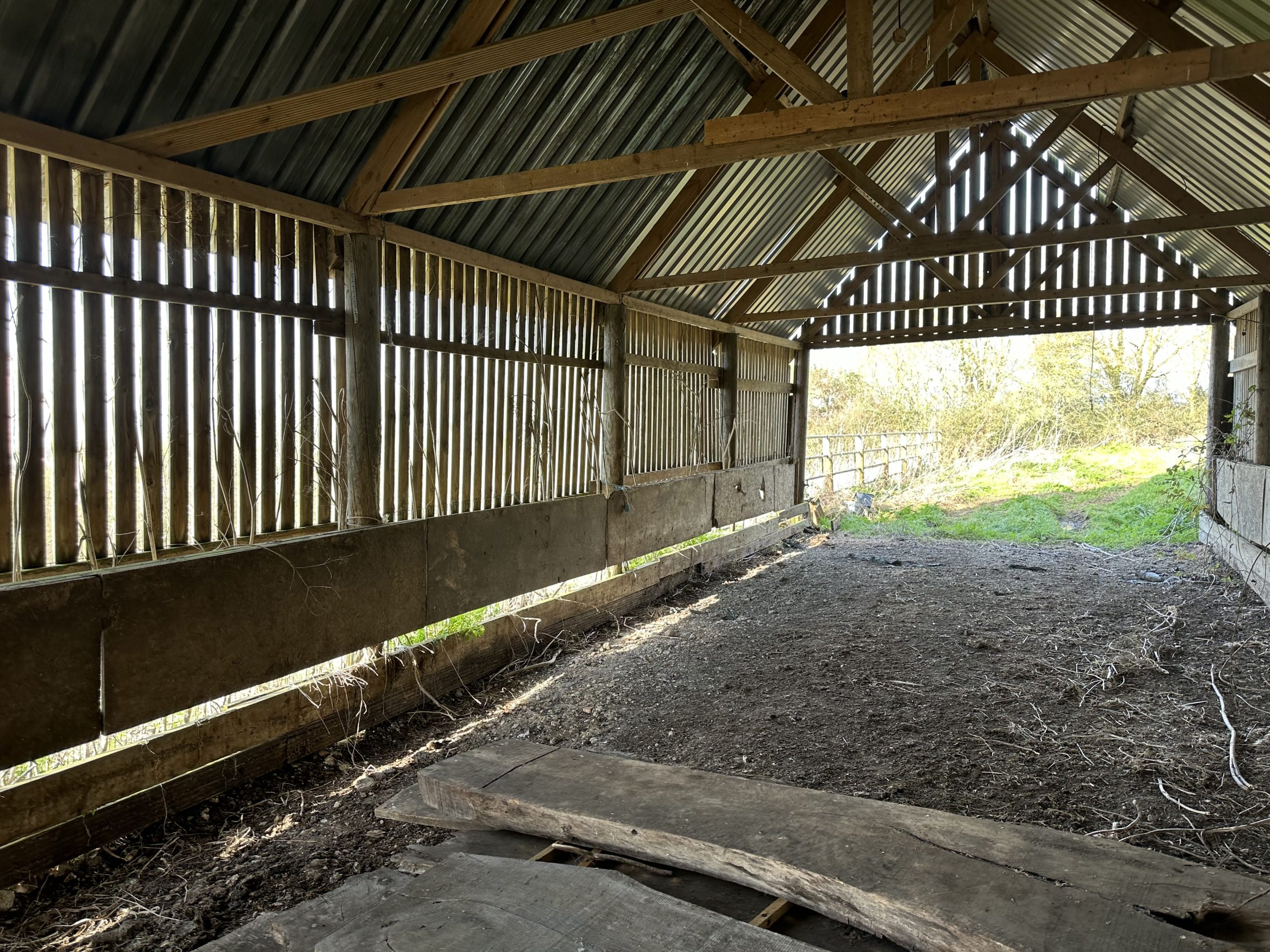 Andrews Farm barn: close detail of the timber cladding boards and corrugated metal roof junction